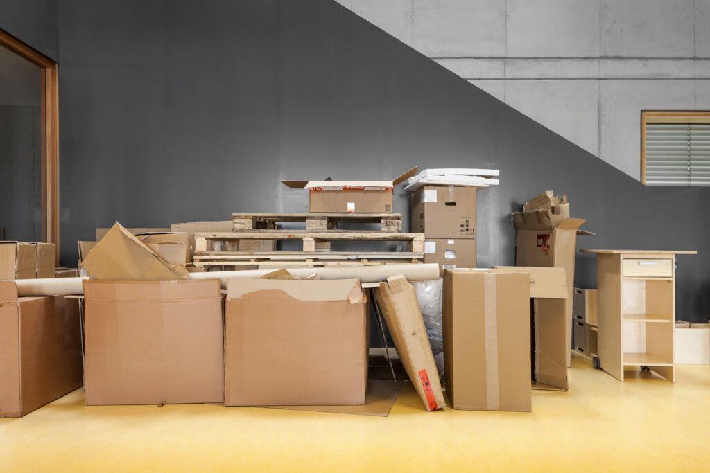 Stapel von Kartons und Möbeln, die für eine Wohnungsauflösung in Berlin bereitstehen, zeigen die sorgfältige Planung und Vorbereitung des Prozesses Haushalt auflösen Berlin