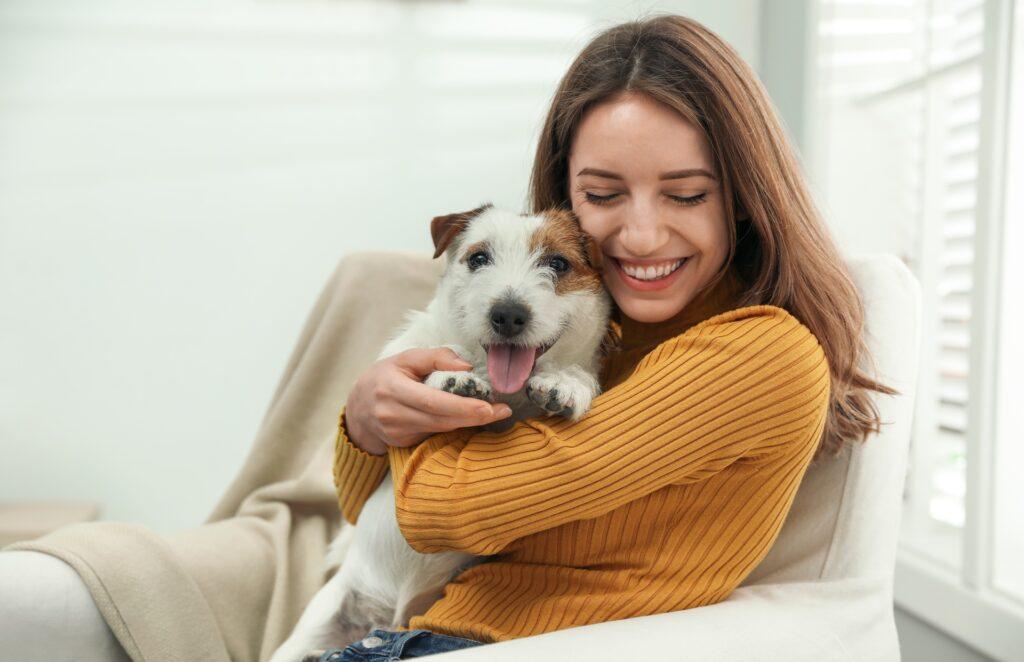 Frau hält Jack Russell auf dem Sofa | Welpenfutter