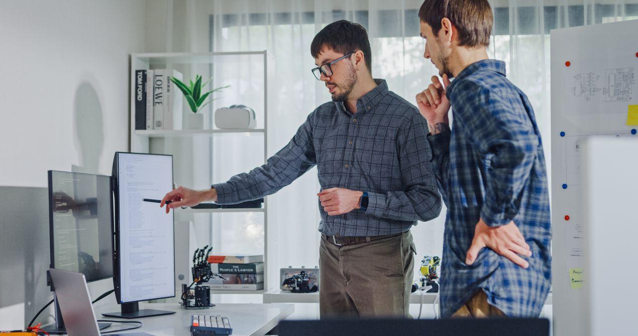 Zwei Experten diskutieren KI Loesungen am Bildschirm, um Strategien fuer digitale Prozessoptimierung zu planen.